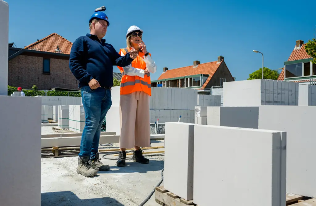 Two people on a construction site, one is Queen Maxima of the Netherlands
